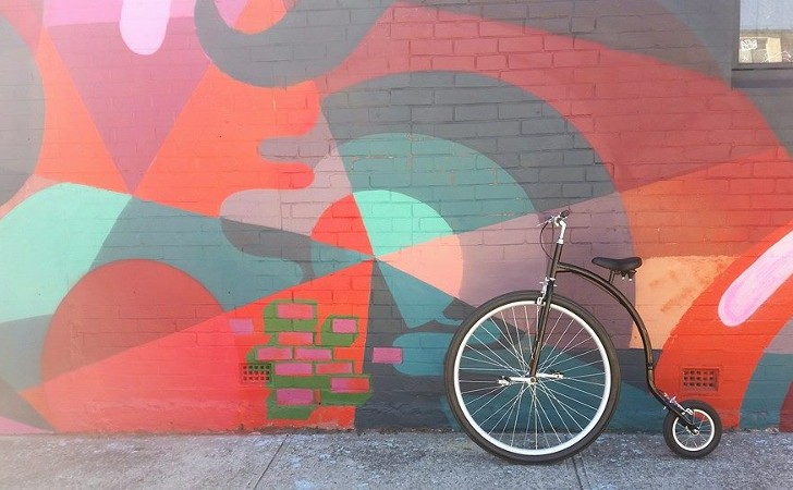 cool retro bike leans against colourful wall mural