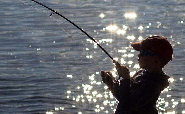 child fishing in sparkling water