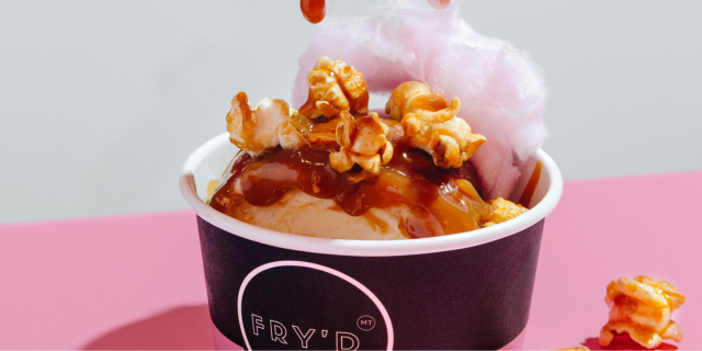 Fry'd ice cream cup topped with caramel sauce, popcorn and pink fairy floss