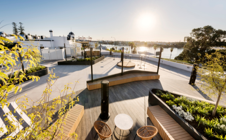 Sunshine reflects over the water in front of the lush waterfront deck at in Fremantle, at Tradewinds Hotel