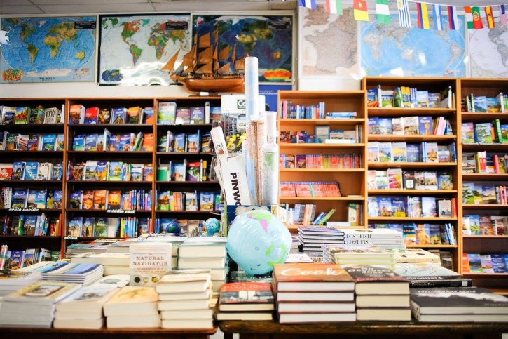 The inside of a shop filled with books, maps, and globes.