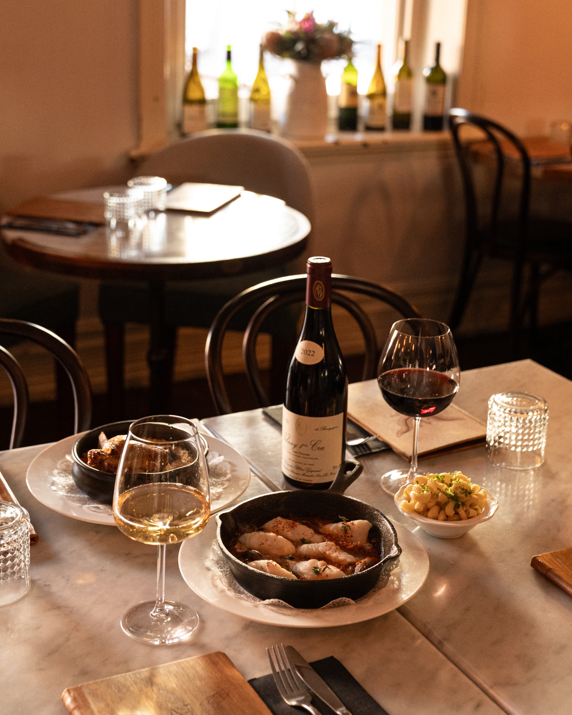 a table full of wine and french dishes