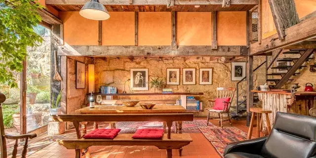 Interior lounge view of Silver Street studio with dining table, chair, exposed beams and artwork on the walls