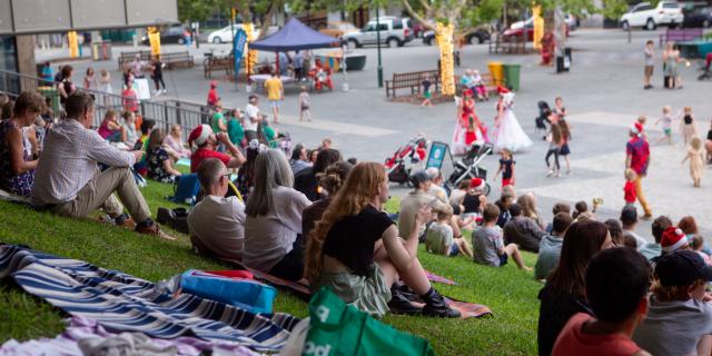 People sitting on the grass slope in Walyalup Koort