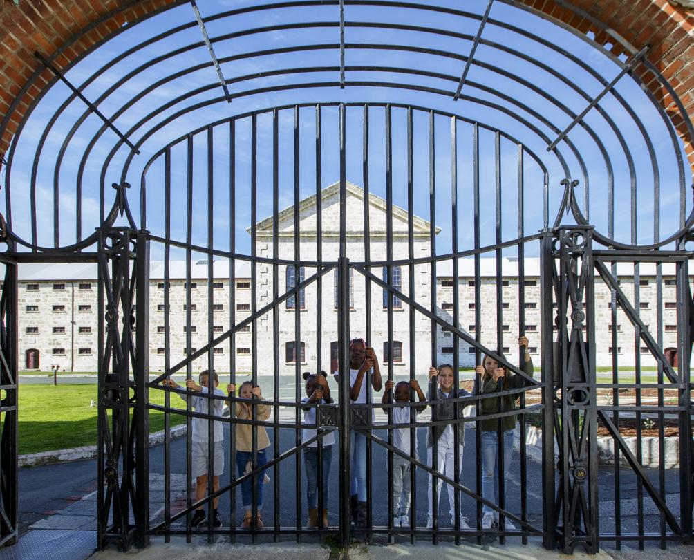 Children standing behind the gates at Fremantle Prison