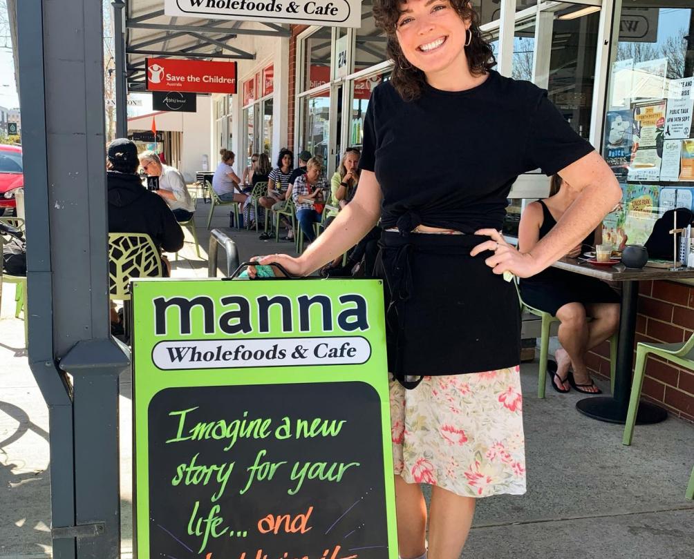 smiling staff member at the front of mana wholefoods. 