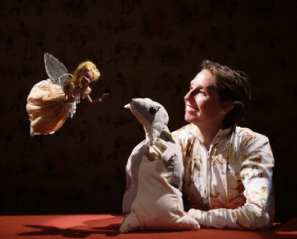 woman using rabbit puppet to talk to a fairy puppet