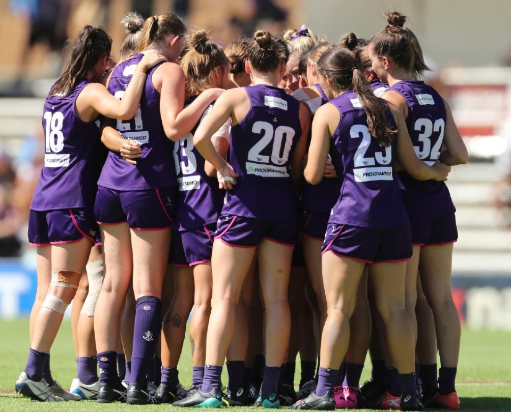 AFLW Dockers team - players in purple uniforms huddled together