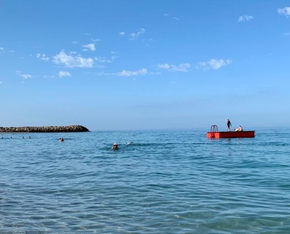 Blue ocean of South Beach with the red pontoon floating on the surface 