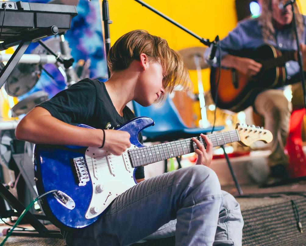 young boy playing guitar at penny lane music school