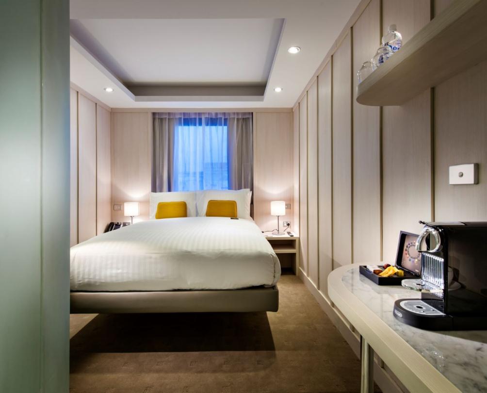 Interior of hotel room with large bed in front of a window