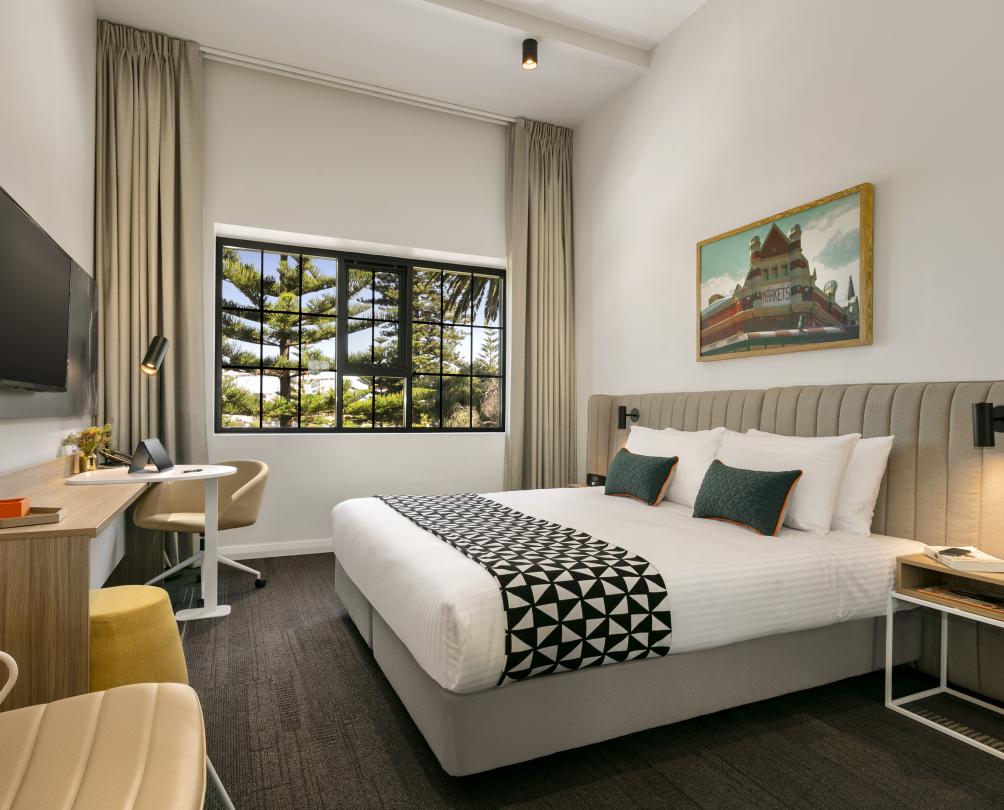 Interior of hotel room, large bed and park views 