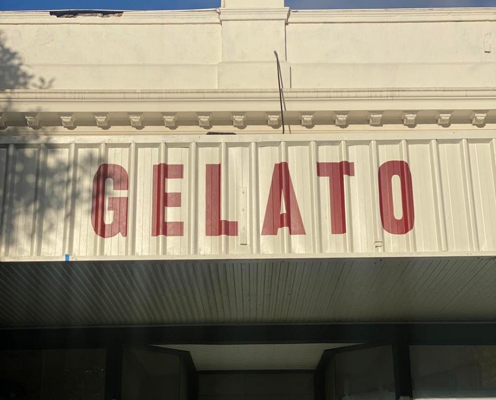 The word GELATO spelled out in red letters on the side of a white building 