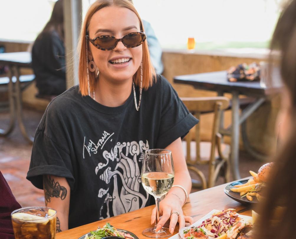Female customer with sunglasses on holding glass of wine at Clancy's Fish Pub Fremantle