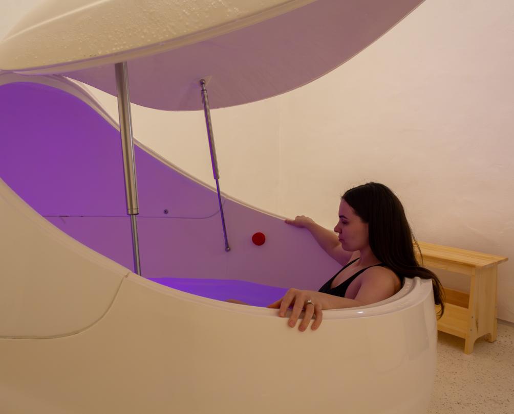 Woman in float tank at Clear Mind Studio Fremantle with purple lighting