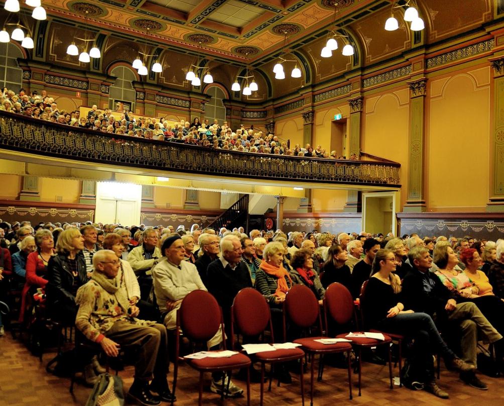 Fremantle Town Hall audience on red chairs facing a stage 