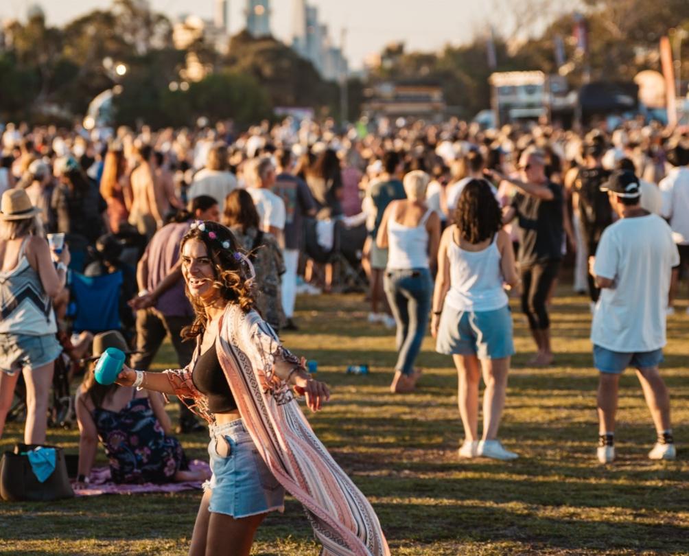 Lady in pink dress with flower crown enjoying a concert