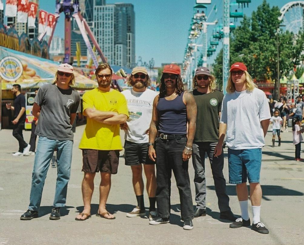 Ocean Alley members pose for a photograph on a busy street.