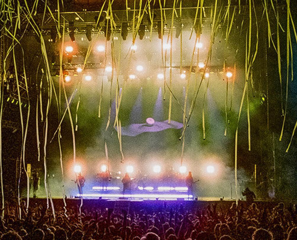 Ocean Alley perform on a stage with two big screens on either side and streamers falling on the audience.
