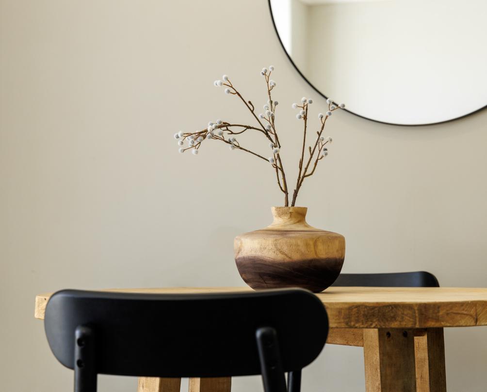 A desk and chair with vase.