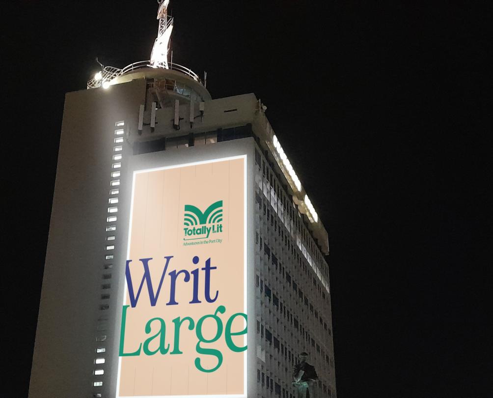  A tall building with a large projection on it with the words 'Writ Large'.