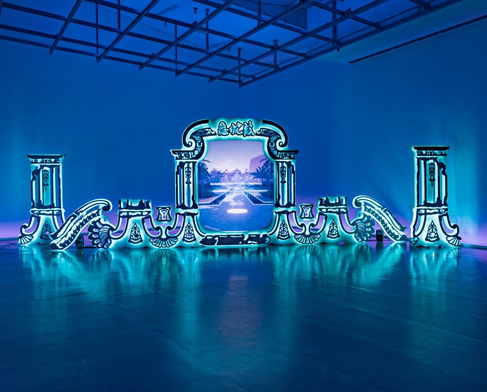 A blue room with a bright turquoise blue mirror installation depicting a portal to a blue and purple world.