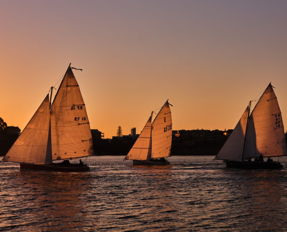 three small boats sailing on a river
