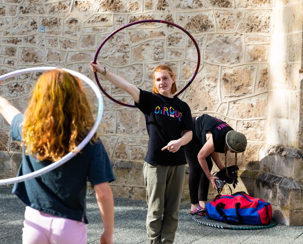 Two people holding hula hoops.