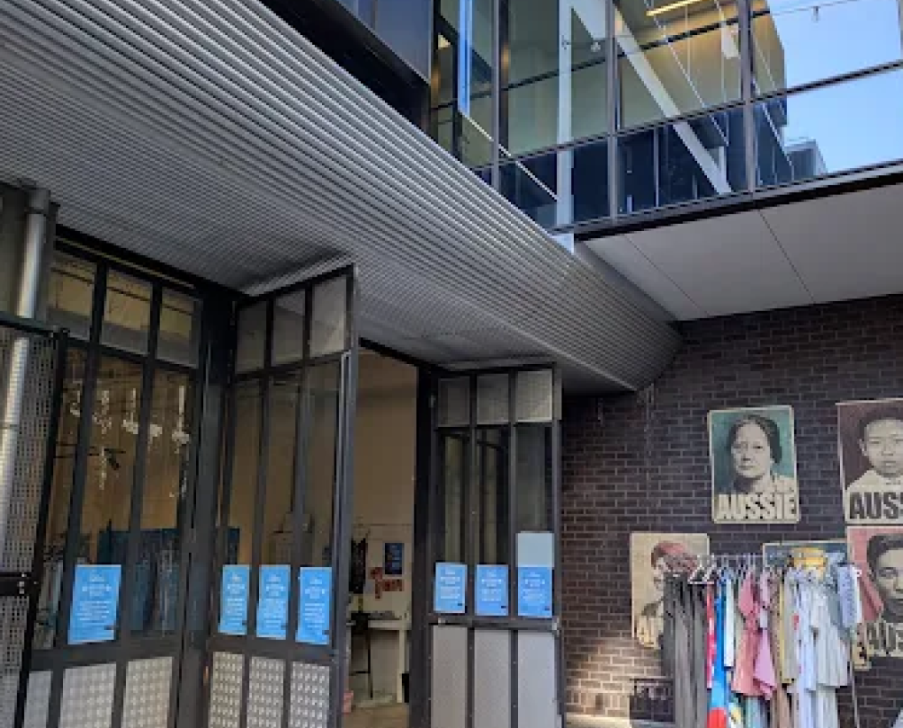 Exterior of a shop with clothes racks outside the door.
