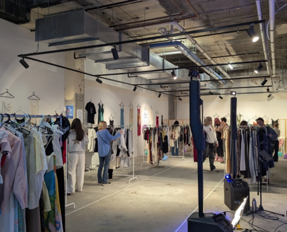 Interior of a shop with white walls and several clothes racks.