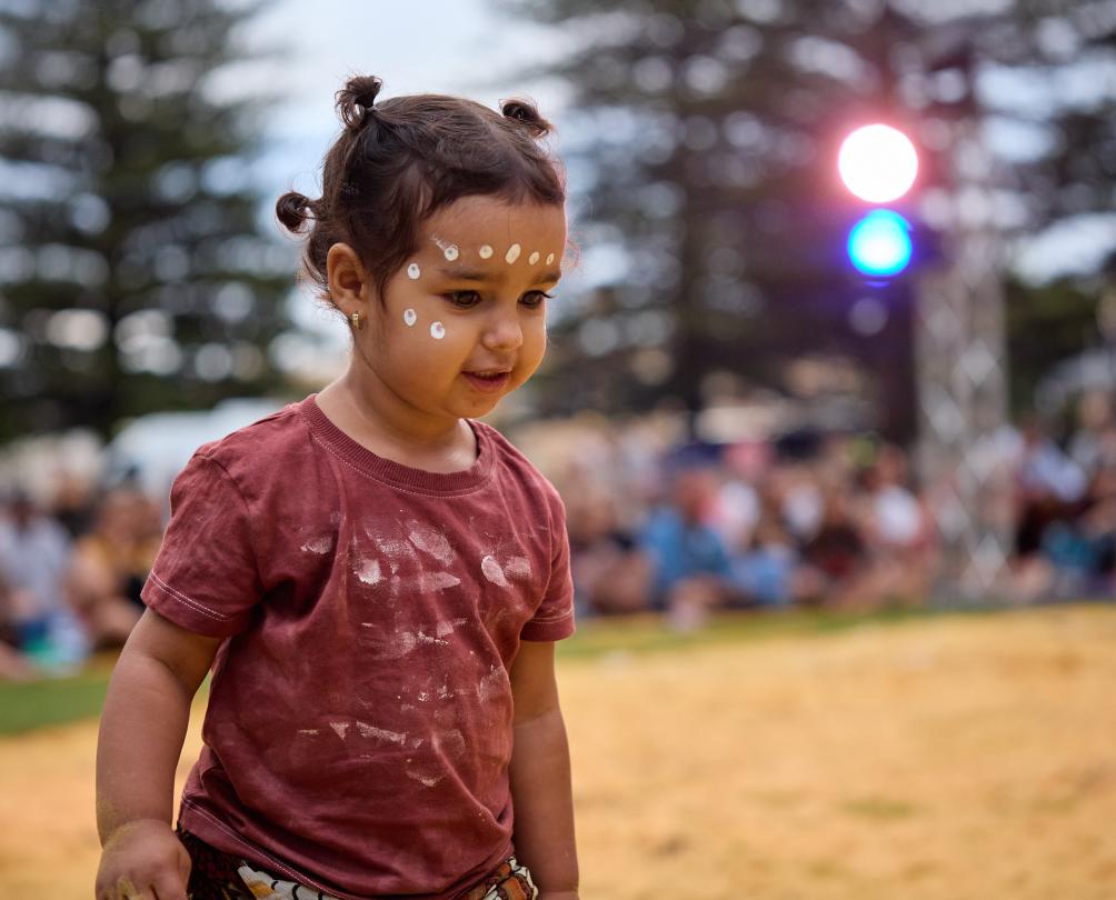 A young Aboriginal child in traditional face paint.