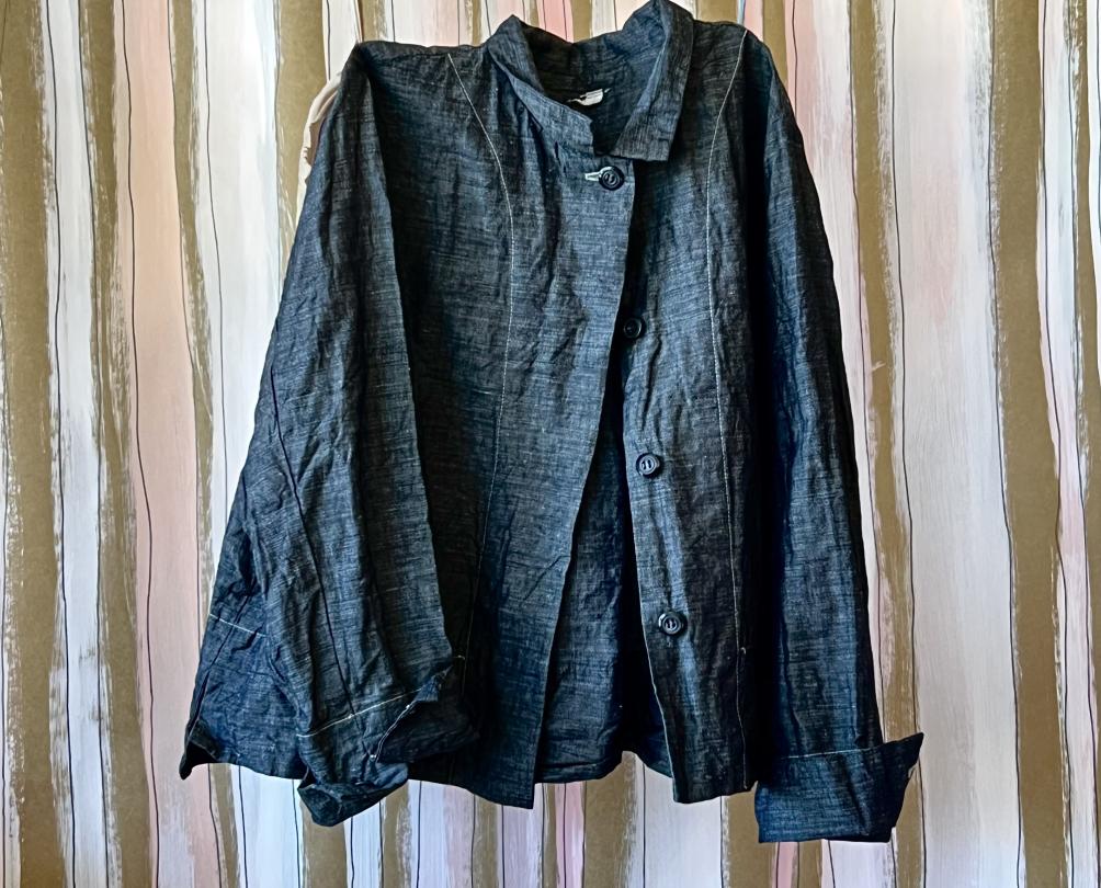 A dark navy linen shirt against a curtained wall.