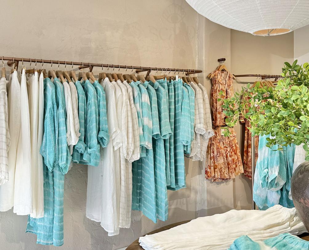 A rack of white and turquoise clothing in a store.