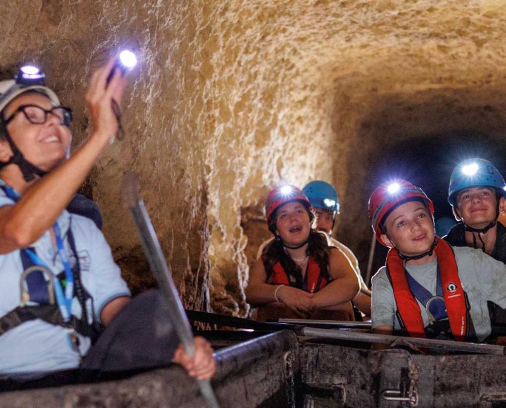 people in a tunnel with flashlights