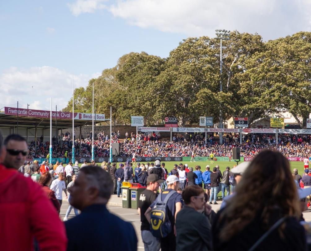 Fans watching a football game in a stadium. 