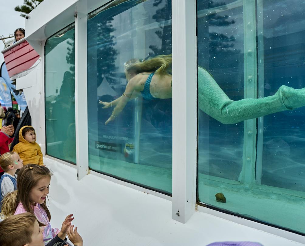 kids looking at mermaids