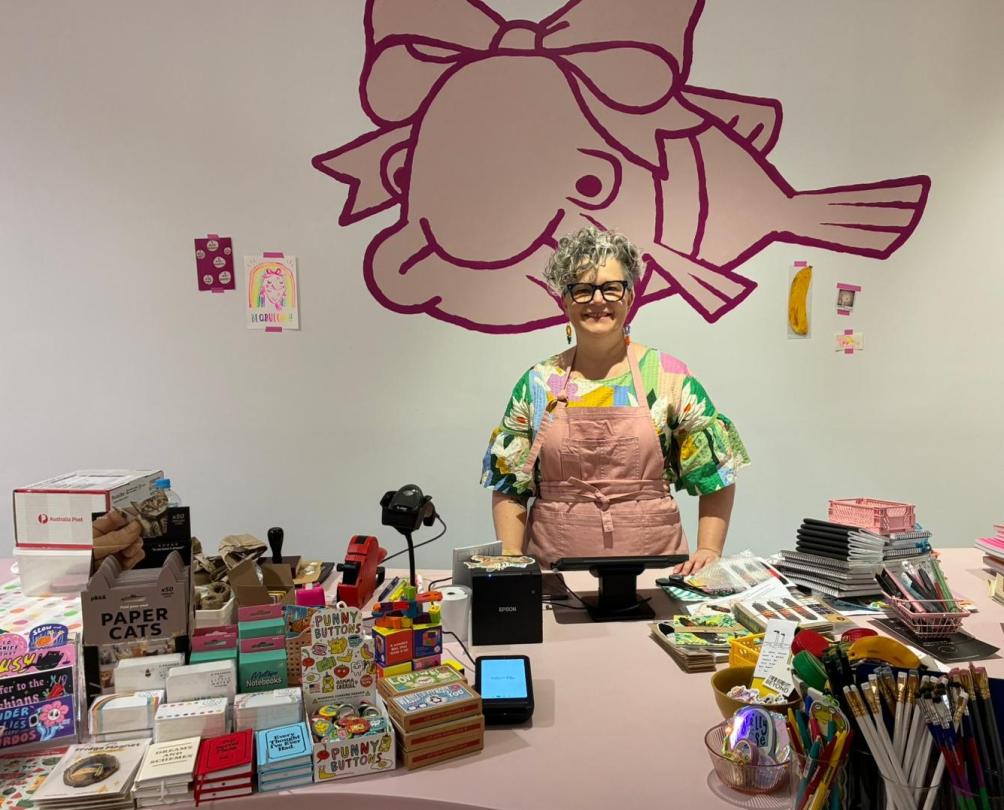 Kristy at her counter with nicknacks and stationery on display 