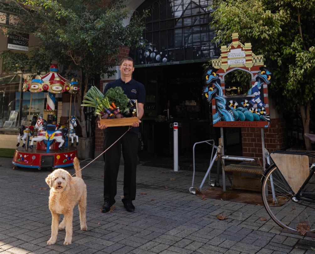 a man and a dog outside the fremantle markets 