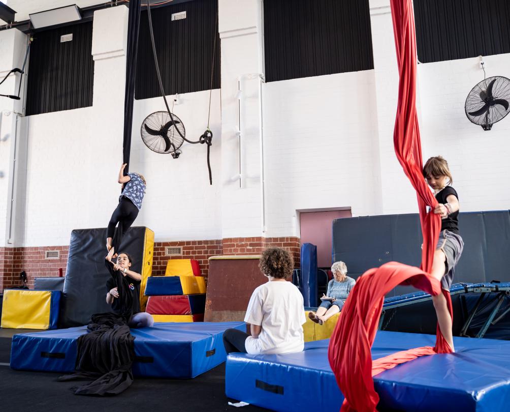 kids hanging from circus ropes
