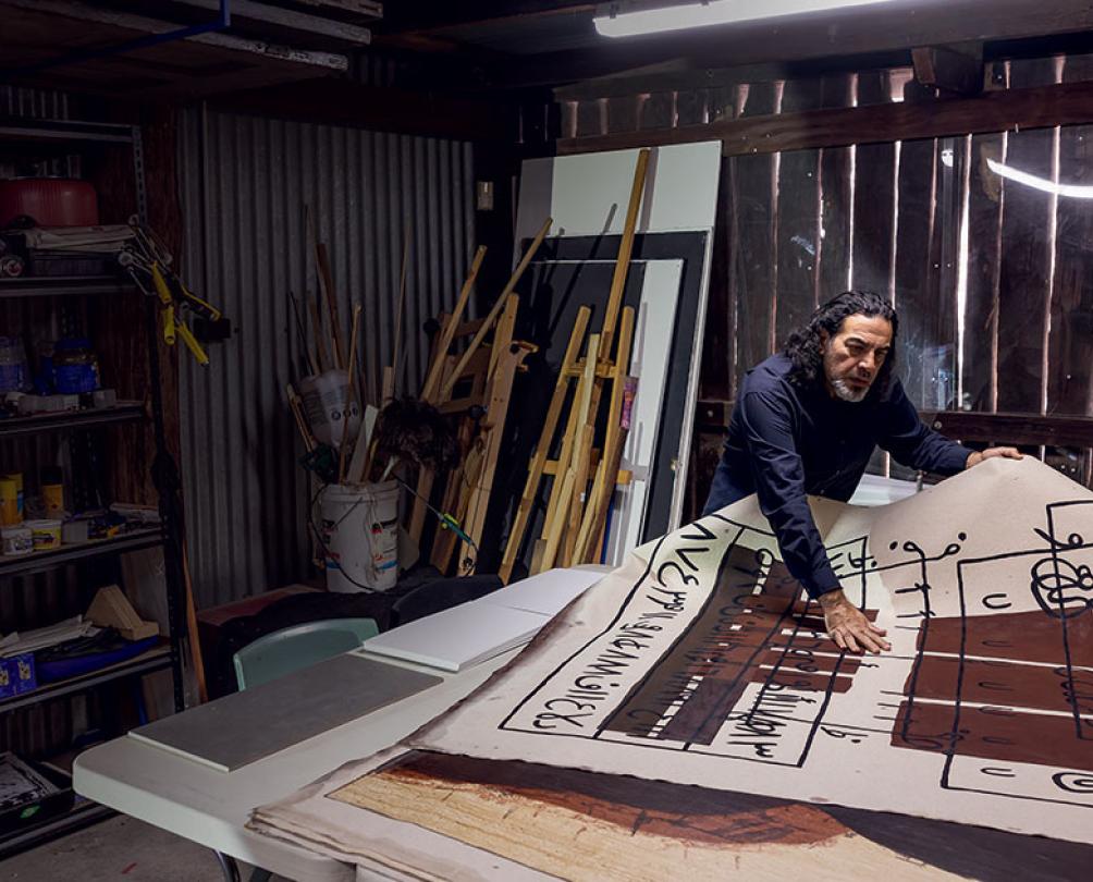 a man working on a piece of art in a shed 