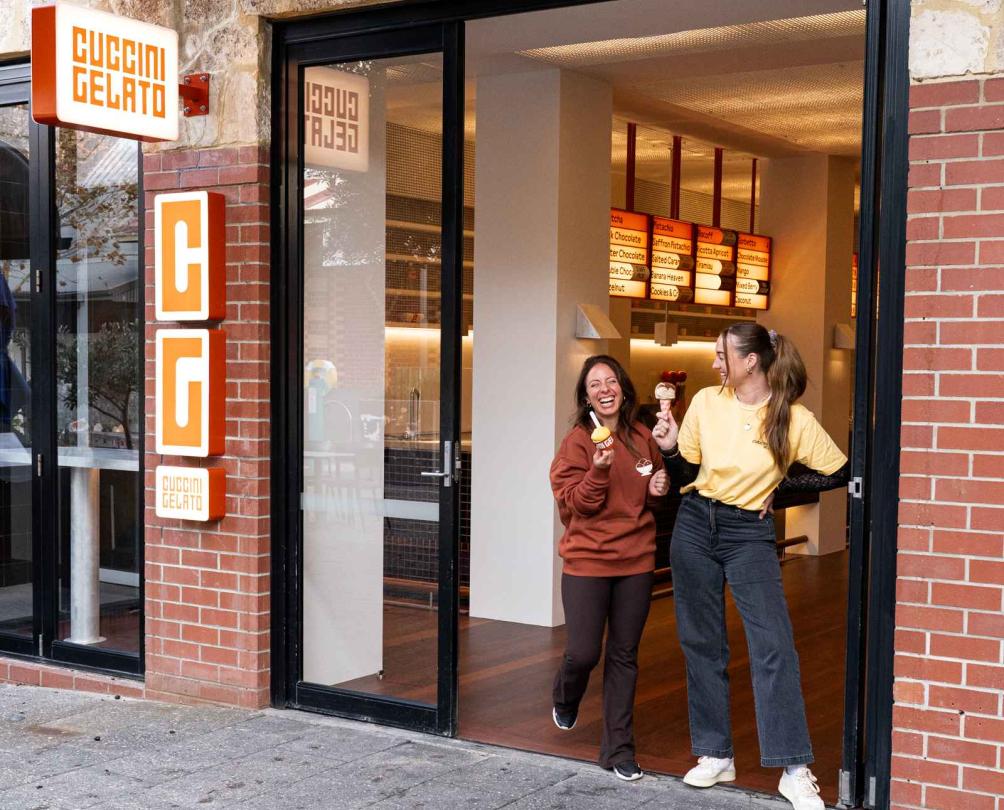 two women standing outside an ice cream parlour on market street