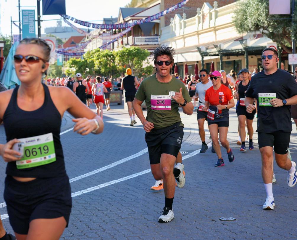 a group of happy runners down the Cappucino strip at Fremantle Running Festival