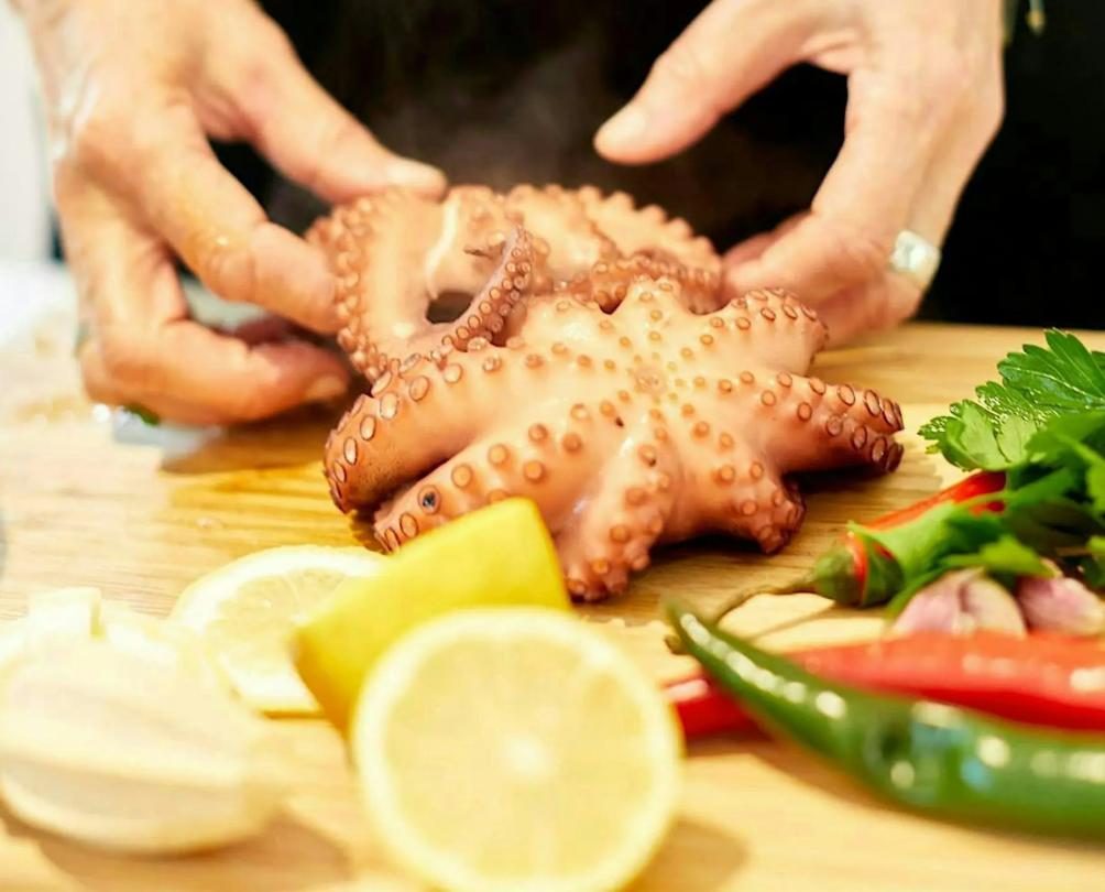 hands cutting a squid for Italian cooking as part of Little Italy by the Sea