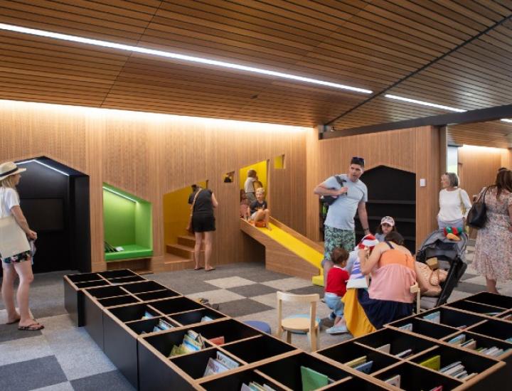 Parents and children playing in the Fremantle Library and exploring the yellow slide and open book boxes