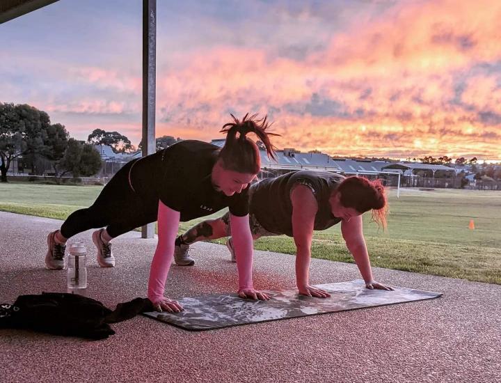 Community Bootcamp - two women exercising at sunrise