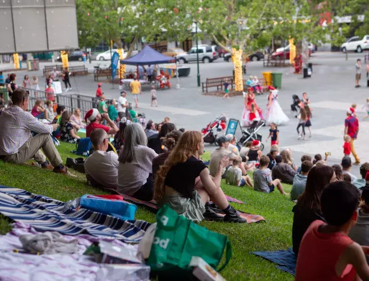 People sitting on the grass slope in Walyalup Koort