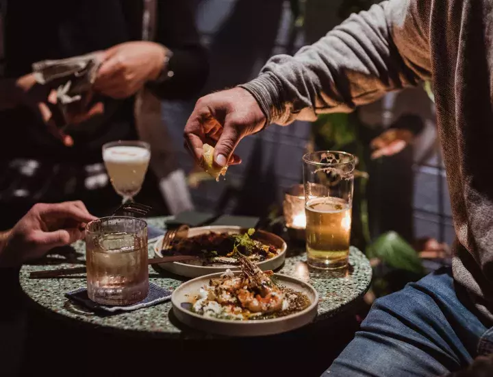 Plates of food and cocktails and beer on table at Wild in the Street, South Fremantle