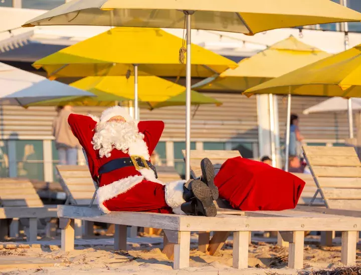Santa puts his feet up at the beach.