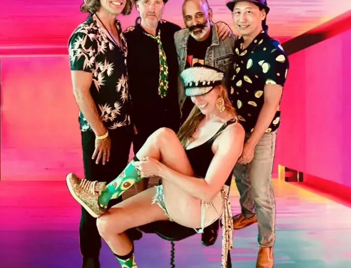 Four men stand behind a woman on a chair wearing avocado-patterned socks.