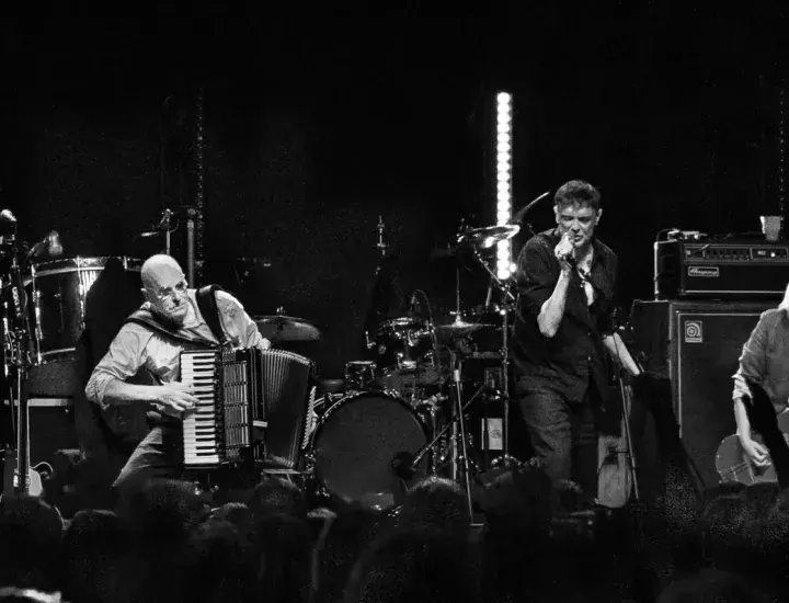 A black and white image of a band playing on a stage.